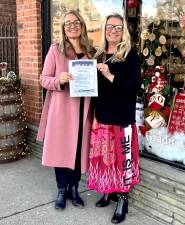 Co-chairs Nicole Repose, owner of Etched in Time Engraving, and Barbara Sullivan, owner of Hip &amp; Chic Boutique with the Home for the Holidays poster.