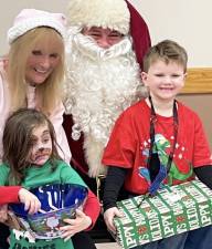 The Sons of American Legion Post 1443 and the Ladies Auxiliary hosted their annual Children’s Christmas Party at the Legion Hall in Greenwood Lake last week for more than two dozen children and their families. Pictured with Santa is the Auxiliary’s Mary Francht and her grandchildren, Kaylee Rose Garcia, who is 4 years old, and Aidan Garcia, who is 7 years old. Photo by Ed Bailey.