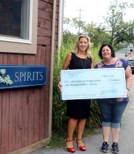 On Wednesday, Sept. 4, Merchant Guild President Corrine Iurato (right), chair of Ladies Night Out, and Kelly Ann Kostyal-Larriler (left), director of Safe Homes of Orange County, posed for a for a symbolic presentation of a check for $1,000, proceeds from the annual event.