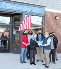 On Tuesday, Dec. 10, Kevin Brand, owner of The Computer Guy, (front right) joined by members of his staff, presented his company’s check for $750 to Glenn P. Dickes, (front left) director of the Warwick Ecumenical Food Pantry. Photo by Roger Gaven.