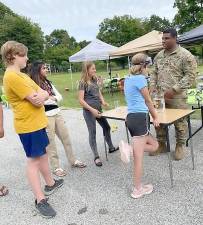 Youth participate in educational activities about impairment and intoxication with Sgt. Julio Fernandez from the National Guard (right) during National Night Out in Warwick.