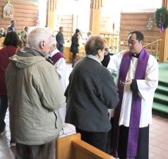Parochial Vicar Father Reynor Santiago administers ashes to parishioners of the Church of St. Stephen, the First Martyr, on Wednesday, Feb. 26.