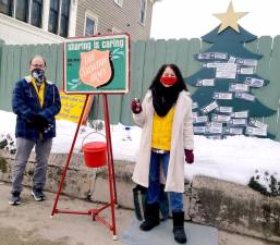 In the true spirit of Christmas Lions Club volunteers Pete and Annmarie Moore “ring the bell” on Main Street to help support the essential gifts of food and shelter provided by the Salvation Army. Photo by Terry Gavan.