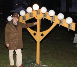 Moshe Schwartzberg lit the Shammash, the ninth candle which was originally used to light the other candles one by one on each day of the eight day celebration. Photo by Roger Gavan.