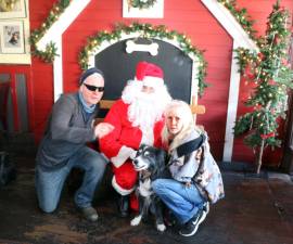 Steve and Chris Kruzik posed with Santa and their 16-year-old Border Collie “Jenna.” As a side note, Jenna has posed with Santa at this event every year. Photo by Roger Gavan.
