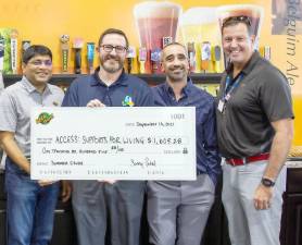 Beer World Sonny Patel, left, recently presented the staff of Access Supports for Living Partners a check for $1,605.28, the proceeds of its “Summer Crush” of 32,106 bottles and cans.