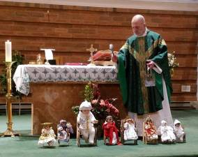Father Jack Arlotta, pastor of the Church of St. Stephen the First Martyr, blessed the Nino Dios dolls placed by the altar.