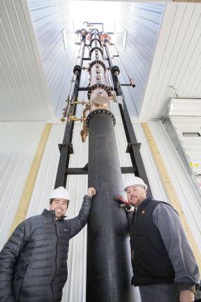 Photo by Robert G. Breese Jeremy Kidde (left) and Jason Grizzanti (right), co owners of the Black Dirt Distillery in Pine Island, stand next to their newly installed 60-foot tall still on Thursday, Nov. 29.