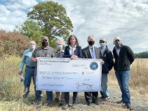 Pictured from left to right are: Left to right, Orange County Soil and Water Conservation District Chairman John Wright, SWCD Director and County Legislator Paul Ruszkiewicz, SWCD Manager Kevin Sumner, state Sen. Jen Metzger, Deputy County Executive Harry Porr, Orange County Farm Bureau President John Lupinski and Warwick Town Supervisor Michael Sweeton hold a giant check for the $400,000 grant secured by Metzger for the Wallkill Floodplain Bench Project. Provided photo.