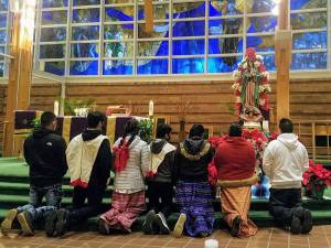 A tradition on the feast day includes bringing flowers and praying before the statue of Our Lady of Guadalupe. Photos by Rocco Battista.