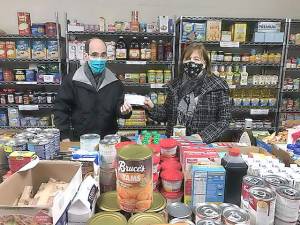 Christine Stage, chair of the Warwick Town Democratic Committee, presents a donation to Glenn P. Dickes, the director of the Warwick Ecumenical Food Pantry. Photos provided by the Warwick Town Democratic Committee.