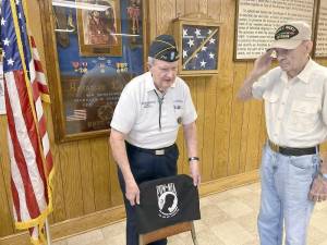 Warwick brothers and World War II veterans Don and Warren McFarland will recognize American prisoners of war and those missing in action with a POW/MIA Empty Chair during the Sept. 8 flag retirement event at American Legion Post 214 in Warwick. The empty chair, displayed at all official American Legion meetings, is a physical reminder of the thousands of Americans still unaccounted for from all wars and conflicts involving America. Warren McFarland, 98, salutes while Don McFarland, soon to celebrate his 96th birthday, places a symbolic cover on the POW/MIA chair. Photo by Stan Martin.