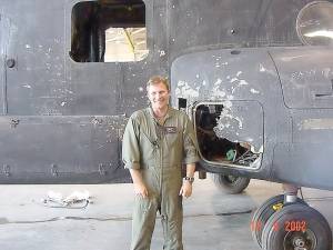 Alan Mack at Fort Campbell in 2002 after Operation Anaconda. He stands in front of his helicopter, which sustained RPG damage during combat.