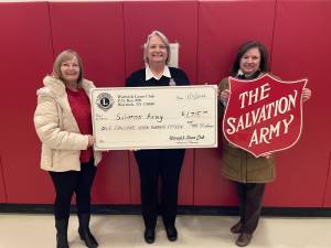 Lions Club Chairperson Carol Buchanan and President Christine Adams present a check for $1,715.00 to Mary Moore of the Salvation Army.