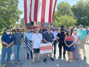 Some of the residents, including members of the Warwick Fire Department and a few motorcycle clubs, gathered under a huge American flag at Veterans Memorial Park on Saturday, July 18, for a “Back the Blue” rally in support of law enforcement. Photo provided by Carmela Borrazas
