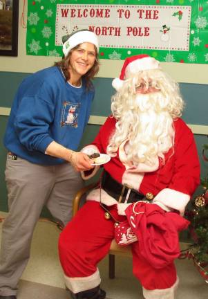 Schervier Pavilion Director of Recreation Kari Call offers Santa a few cookies.