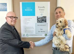 Provided photo Friendly Visitor Program Board Chairperson Vince Copello, left, shakes hands with Dr. Anthony Martini after posting a new display in the doctor's Forester Avenue office regarding the Town of Warwick's Friendly Visitor Program.