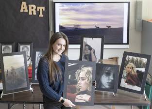 Warwick Valley High School senior Nicole Kellan poses for a portrait with some of her photographs on March 18, 2022.