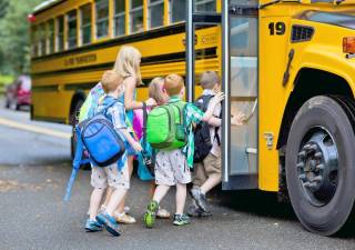 A group of young children getting on the schoolbus