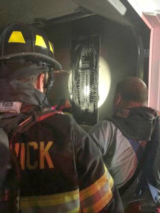 Firefighter Kevin Trass and 2nd Asst Chief Andrew Lemin investigate electrical fire this past Sunday morning.