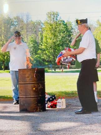 Tom Brennan presents worn American flags to Frank Gilner and Walter Parkinson for ceremonial burning.