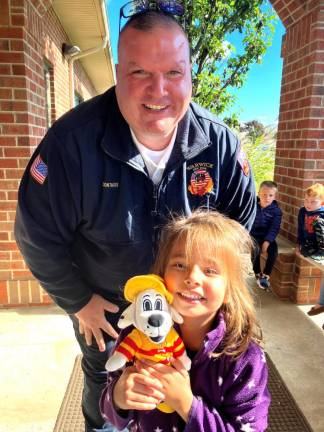 Warwick Fire Department Chief Mike Contaxis stops for a photo with a student at Rythem &amp; Rhyme Child Care during Fire Prevention Week classes.