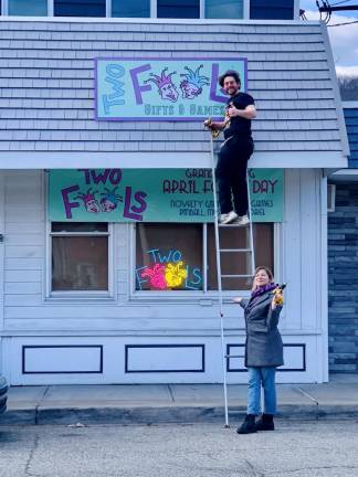 Tepper and Nicola Saffren hang the sign for their new business in Greenwood Lake.
