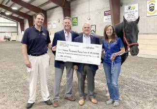 Pictured from left to right are: Josh Simon from EBI Consulting, George Gnad from Lenders Capital Realty Services, Matthew Victor from Newmark and Winslow Executive Director Sue Ferro with “Skunk,” a gentle Winslow horse. Provided photo.