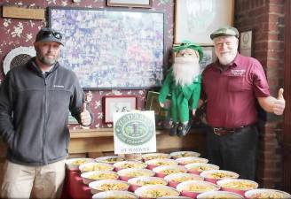 John Christison of Yesterday's Pub and Bo Kennedy of HERoes In Deed show the meals Christison prepared through a grant from HERoes In Deed before they are packaged up for delivery.