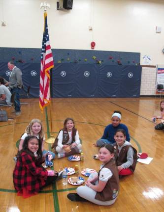Students sit near the flag enjoying some breakfast.