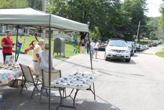 A long line of cars with friends flying balloons and dropping of presents at the reviewing area neighbors had set up to watch a nonexistent tractor race. Photos by Roger Gavan.