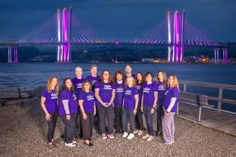 Staff from the Ramapo Catskill Library System poses in front of the lit-up Mario M. Cuomo Bridge.