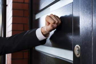 Close-up of hand knocking on the door