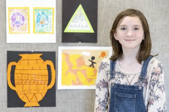 Park Avenue Elementary School fourth grader Pamela McKay poses for a portrait in front of some of her artwork on March 16, 2022.