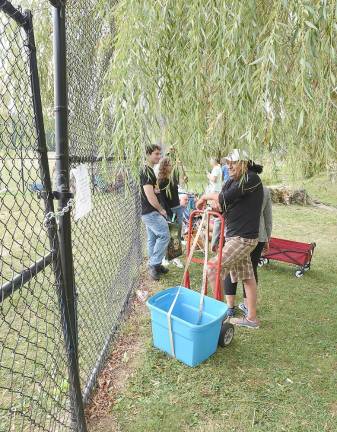 The man with the blue bin was the first shopper to be admitted onto the basketball court Sunday morning. He was one of six hundred twenty-five people who walked through the gates in just the first three hours that they were open.