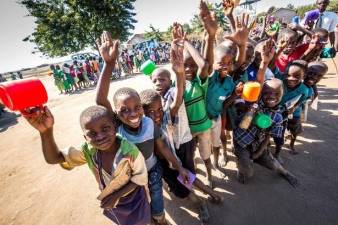 Children in Malawi waiting to be served nutritious porridge at school.