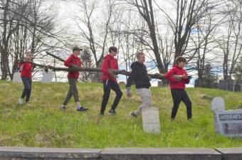 Members of Boy Scout Troop 45 carry a large tree limb out of the Amity Cemetery on Saturday, April 23.