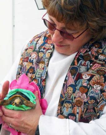 Rev. Lynne Severance, pastor of the Sugar Loaf United Methodist Church, blesses a turtle during last year's service. The church will hold the annual blessing of animals on Saturday, Oct. 20.