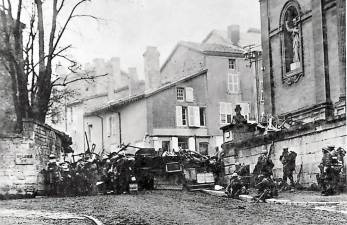 Soldiers of the 353rd Infantry near a church at Stenay, Meuse, in France, wait for the end of hostilities.