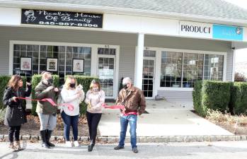 On Dec. 2, Town of Warwick Supervisor Michael Sweeton (right) and members of the Warwick Valley Chamber of Commerce joined owner Nicole Ando Benoit (cutting ribbon) and her staff to celebrate the fourth anniversary of Nicole’s House of Beauty and the grand opening of Product Junkie with a ribbon-cutting ceremony. Photo by Roger Gavan.