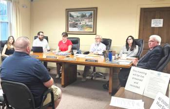 Seated from left to right: Deputy Village Clerk Jennifer Mante, Trustee Thomas McKnight, Trustee Mary Collura, Mayor Michael Newhard, Trustee Carly Foster, and Trustee Barry Cheney during the July 3, 2023 meeting. Seated in front is Warwick Fire Chief Michael Contaxis.