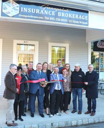 Photo by Roger Gavan On Friday, Nov. 17, Town of Warwick Supervisor Michael Sweeton (left) and members of the Warwick Valley Chamber of Commerce joined owners Marcin (cutting ribbon) and Magdalena Luc, their staff, relatives and friends to celebrate the grand opening of the new office with a ribbon-cutting ceremony.