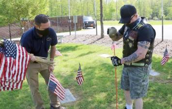 Orange County Executive Steven M. Neuhaus and Kenneth Wilson, a U.S. Navy veteran from Middletown, place a flag at the county’s Veterans Memorial Cemetery on Goshen on Friday, May 22. Photo provided by Orange County.