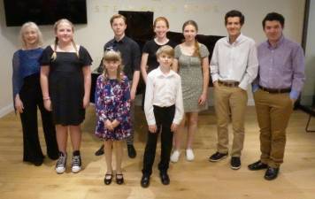 Piano students (l-r) Ann Lewkiewicz, Cole Aronov, June Wetherell-Toro, Lionel Wolfe, Grace Stough, Wesley Lewkiewicz, Gwen Redman, Owen Durgin, and Nathan Durgin at the Steinway Piano Gallery in Paramus, NJ.