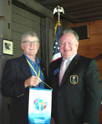 Photo by Leo R. Kaytes Rotary District Governor James Damiani, right, presents a Rotary International banner to Warwick Valley Rotary President Dave Eaton during his Sept. 27 visit.