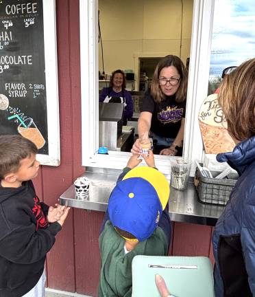 Warwick teachers scoop and serve ice cream to raise funds for scholarships.