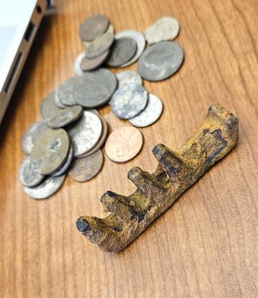 Joe Santandrea and his sons suspect this artifact might be an ancient Roman iron key, pictured along with coins found during previous metal detecting excursions.