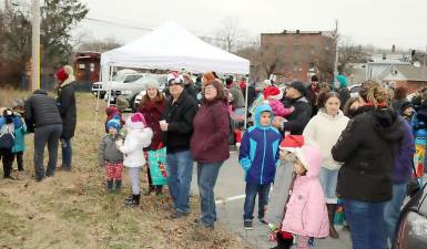 By 9:30 a.m. and in spite of cold temperatures and a snowstorm warning, a large crowd had gathered in the Chase Bank parking lot as a diesel locomotive pulled a train of railroad freight cars into its first stop, the Village of Warwick.