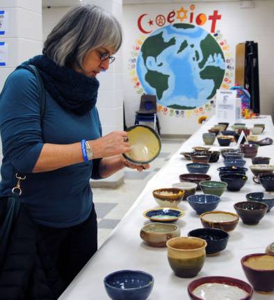One guest tries to decide which pottery bowl to purchase, with all proceeds going to Empty Bowls to feed those in hunger in the Town of Warwick.