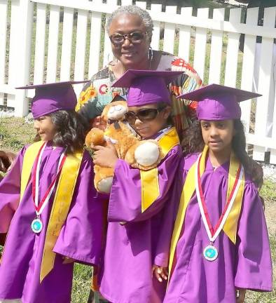 Director Cecelia Cenot poses with graduates Madison Thompson, her twin brother Roy and Genesis Flores, all age five, at Love Grows Child Care in the Village of Warwick. Provided photos.